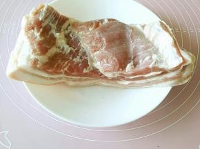 首先选择一块五花三层的带皮猪肉，洗净之后剔去多余的筋膜