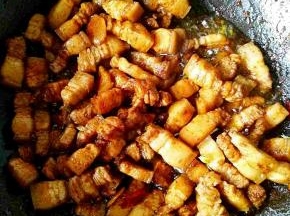 放入肉块继续煸炒片刻，加入料酒，老抽，生抽，炒匀。