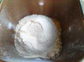 把面包粉、奶粉、酵母加入面包桶里。