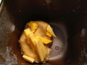 把黄油放在室温软化，改刀成小块。和面20分钟后，放入黄油。再和面30分钟。