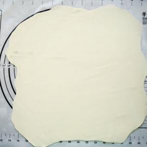 将面团擀成薄面片。