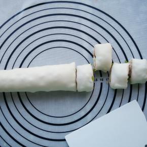 从一边卷起成圆柱形，再切成宽3厘米左右的小剂子。