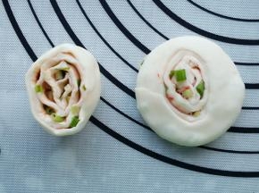 将小剂子竖直放，并用手掌压扁成饼。