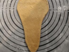 取一个面团，搓成水滴状再擀成倒三角形。