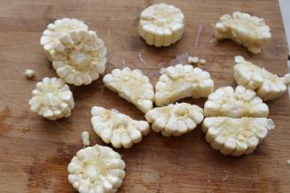 越来越喜欢新鲜玉米入菜，切小段，再一分为二。