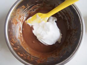 取三分之一蛋白霜加入可可面糊中切拌均匀后倒入剩余的蛋白中，切拌均匀。