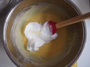 蛋白放入无水无油的盆子中，打出鱼眼泡、出现纹路、纹路明显后各加入三分之一糖，打发至湿性发泡状态。蛋白霜分两次加入蛋黄糊中，切拌均匀。