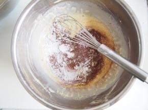 准备可可蛋糕片，同样准备3个蛋黄加入牛奶和玉米油搅拌均匀后，将可可粉和面粉筛入蛋黄糊中。