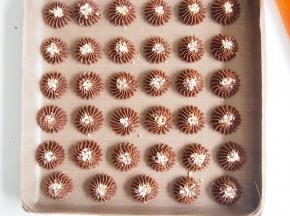 在曲奇中间撒上坚果碎，用手轻轻压一下。烤箱预热至170度，中层上下火，18分钟左右即可（要根据自己的烤箱脾气和曲奇大小适当调整时间哦），烤好的曲奇晾凉。