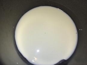 纯牛奶放入奶锅加入细砂糖，开最小火，把糖煮完全融化。