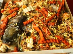 把炒好的蔬菜铺到鱼身上。