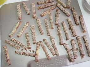 将融化的白巧克力放入裱花袋，在饼干上挤上线条，晾凉后凝固即可。