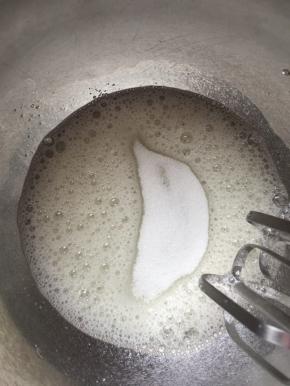 7，取出蛋白用电动打蛋器打出鱼眼泡时加入1/3的细砂糖，继续搅打。