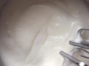 9，当打至蛋白变得浓稠，表面出现纹路时加入剩下的细砂糖，依旧继续搅打。