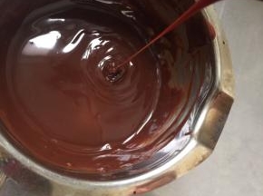 边加淡奶油搅拌边观察，全程都坐在热水中不动，直到甘纳许出现油光发亮时离水再加淡奶油搅拌至顺滑。提起挂刀甘纳许可以流程细细的线。