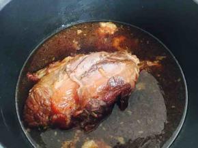 这是打开电压力锅锅盖后牛腱子炖熟的状态。
因为我只放了一瓶啤酒，没有加水，水位较低，所以牛腱子上边没有上色，没关系我们再加工一下，牛腱子的颜色就一致了。
如果您用的是普通的锅，就不存在牛腱子颜色不一样的状况，因为您可以随时打开锅盖，翻动牛腱子，使其上色均匀。