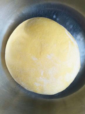 南瓜泥放凉加入酵母混合均匀，倒入成面粉的盆中，活成光滑的面团