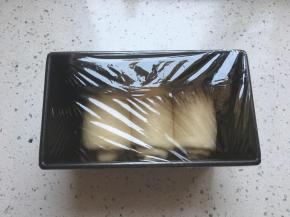 拍掉气泡，翻面，自上向下卷起，放入学厨黑金刚吐司盒中排好