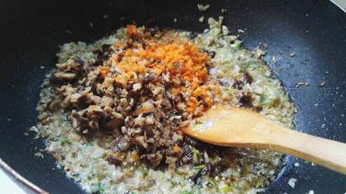 放入香菇碎、胡萝卜碎翻炒。