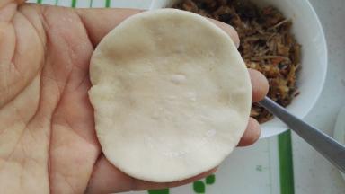 取一个面剂，擀成一圈薄中间厚的面片（我包包子不擀皮，都是两手手指转圈捏的，当然是一圈薄，中间厚)。