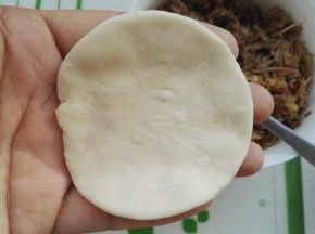 取一个面剂，擀成一圈薄中间厚的面片（我包包子不擀皮，都是两手手指转圈捏的，当然是一圈薄，中间厚)。