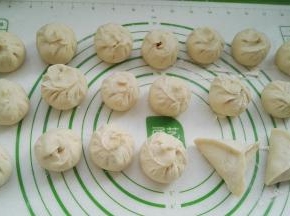 依次包好所有的包子。之前包过两锅包子，馅不够了，剩下的包成糖三角了(糖三角里面包的是： 白糖+少量面粉掺匀，添加面粉是为了防止糖浆烫嘴)。