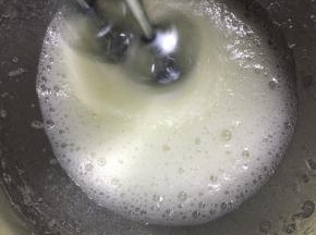 先用电动打蛋器低速打发至有粗泡，加入1/3的白砂糖B，继续中速打发