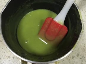 接下来做淋面，白巧克力隔水融化后，慢慢加入淋面用的淡奶油，抹茶粉单独用一点点奶油加热后化开，均匀后倒入巧克力奶油溶液中，然后趁热加入吉利丁粉，搅拌至吉利丁粉融化。巧克力淋面溶液过筛一遍，等温度降到30度，差不多用手试一下温温偏冷即可，开始淋面，从蛋糕中间缓慢倒下，然后淋边沿，自然流下的淋面或中途凝固