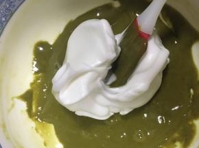 用刮刀舀取1/3的蛋白霜到抹茶蛋黄糊中，翻拌均匀，注意手法不要搅拌，是上下来回翻拌