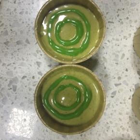 浅色的抹茶蛋糕糊裱花袋剪一个稍大的孔，挤入在杯子中，上下轻磕几下震去大气泡，深色的蛋糕糊裱花袋剪小孔，这样画圈挤入
