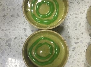 浅色的抹茶蛋糕糊裱花袋剪一个稍大的孔，挤入在杯子中，上下轻磕几下震去大气泡，深色的蛋糕糊裱花袋剪小孔，这样画圈挤入