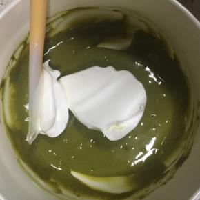 用刮刀取1/3的蛋白霜到抹茶蛋黄糊中，翻拌均匀，注意手法是J字型上下翻拌，不要搅拌