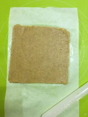 取出冷藏好的面团，面板上放上一张油纸，把面团放在油纸上擀成尽可能大的长方形（厚2mm）切去多余的边