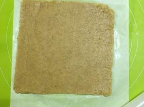 取出冷藏好的面团，面板上放上一张油纸，把面团放在油纸上擀成尽可能大的长方形（厚2mm）切去多余的边