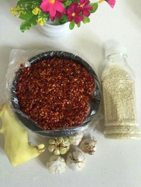 准备好所需食材：
生姜一块削皮备用，蒜瓣5个，白芝麻适量，辣椒粉（可以去菜市场调料店买现成的辣椒粉，也可以自己在家用研磨杯研磨辣椒粉，要颗粒大一点的辣椒粉做出来的辣椒油才好吃。）
