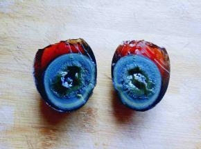 小心的把皮蛋对切开，一切二，(可以把刀沾一些水，这样比较好切，不容易沾刀。)