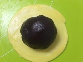 取30g红豆沙滚圆包入