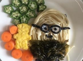 煮熟的紫菜摆成小黄人的衣服，小熊放在小黄人旁边，摆上秋葵和胡萝卜