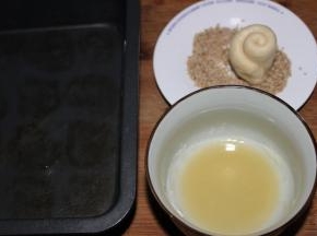 准备好脆底的材料，10克植物油和10克面吩咐混合均匀，另一个盘子装一些芝麻，将面包的胚子的切口先沾一些油，再沾上芝麻