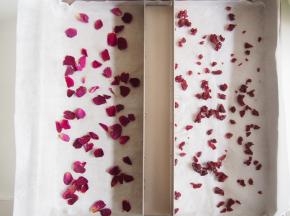 烤盘铺上油纸，用条形饼干模具隔开，一边放入玫瑰花瓣，一边放入蔓越莓碎