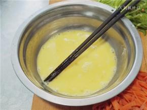 鸡蛋磕入容器中。放入少许料酒，打散；