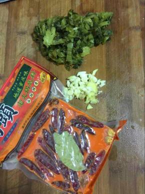 酸菜鱼里面的酸菜洗干净切成末，蒜瓣剁碎，生姜切成丝，桥头火锅底料20克备用！
