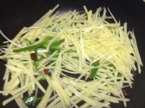 然后加土豆与青椒翻炒。