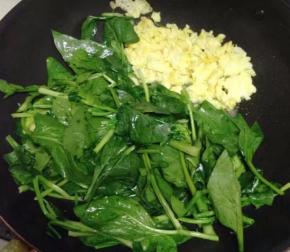 然后将鸡蛋推到一边，用锅底油炒菠菜。