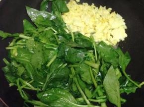 然后将鸡蛋推到一边，用锅底油炒菠菜。