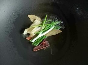 锅里倒入适量的食用油加热，爆香葱姜，八角，香叶，干红辣椒