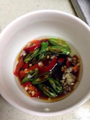 锅里烧热油淋在放有椒圈和蒜的碗里，加2勺生抽。