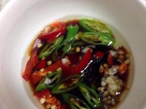 锅里烧热油淋在放有椒圈和蒜的碗里，加2勺生抽。