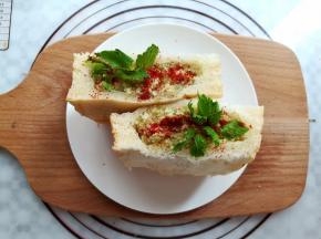 在厚吐司里加入豆腐茄子酱，撒上适量的辣椒粉，插上几片芹菜叶装饰一下