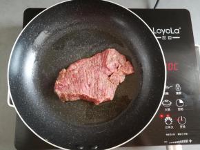 不粘锅里倒入适量的橄榄油，放入牛排